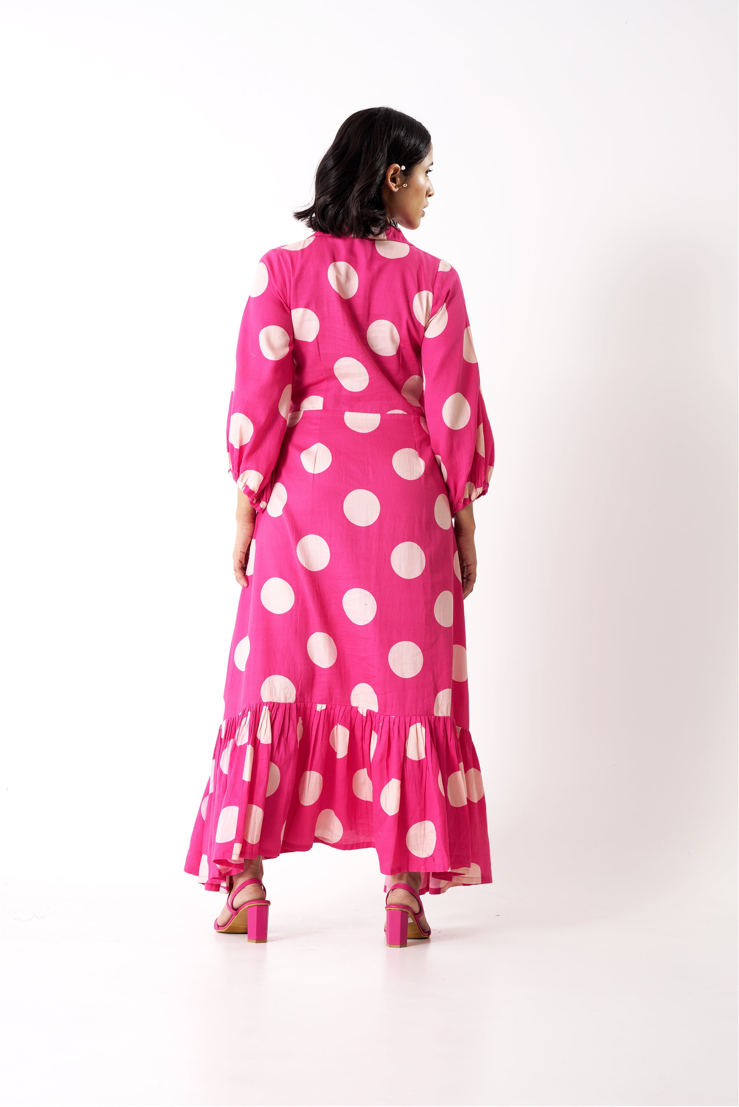 Aine's polka dot midi dress with pink heels, back view.